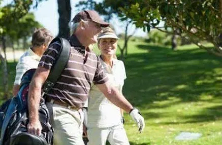 Golfers walking together on a sunny course.